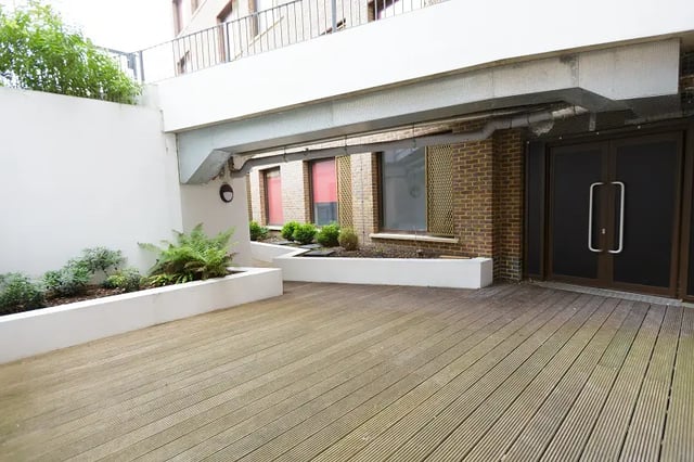 Decking area with planters and building entrance exterior at AXO New Cross in London Student Accommodation