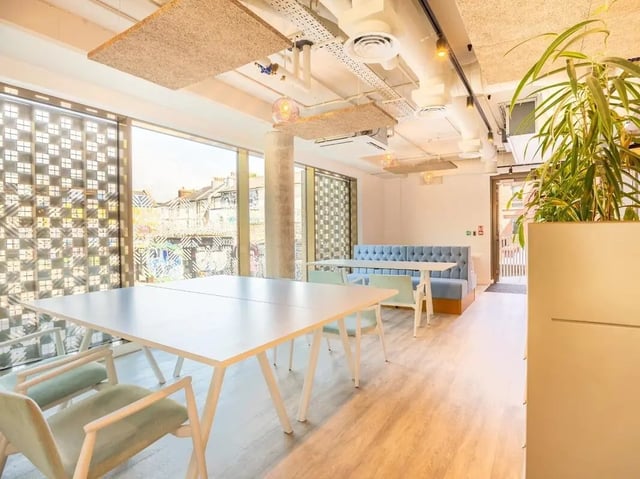 White tables blue booth chairs plant living area at Promenade Student Living in Brighton Student Accommodation