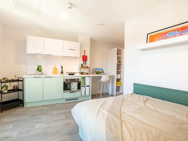 Bed study desk kitchen cabinets and oven studio apartment at Promenade Student Living in Brighton Student Accommodation