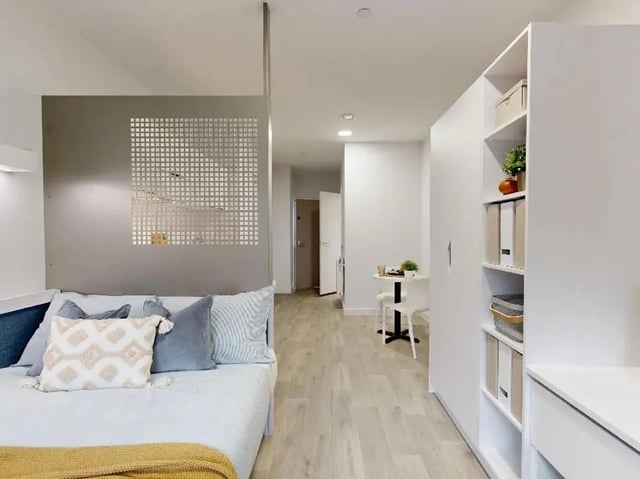 Bed with pillows bookshelf and desk bedroom at Promenade Student Living in Brighton Student Accommodation