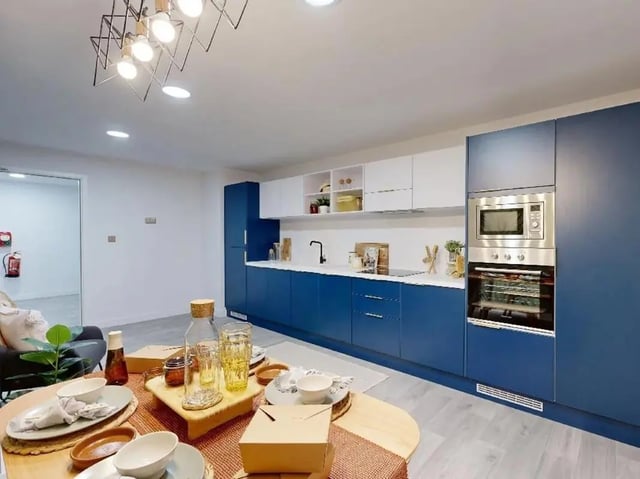 Modern blue and white kitchen with appliances and table kitchen at Promenade Student Living in Brighton Student Accommodation