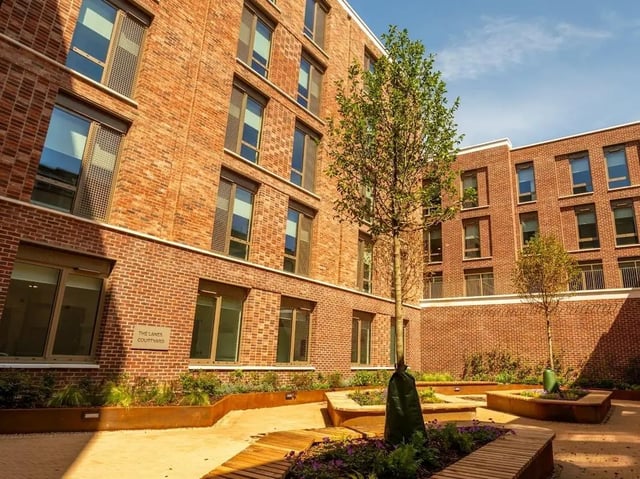 Brick building courtyard with benches and trees exterior at Promenade Student Living in Brighton Student Accommodation