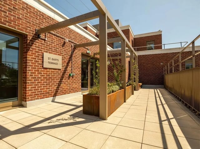 Brick building with planters and outdoor seating exterior at Promenade Student Living in Brighton Student Accommodation