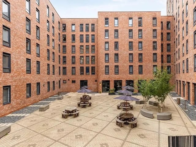 Picnic tables under umbrellas courtyard exterior at Globe Works in Birmingham Student Accommodation
