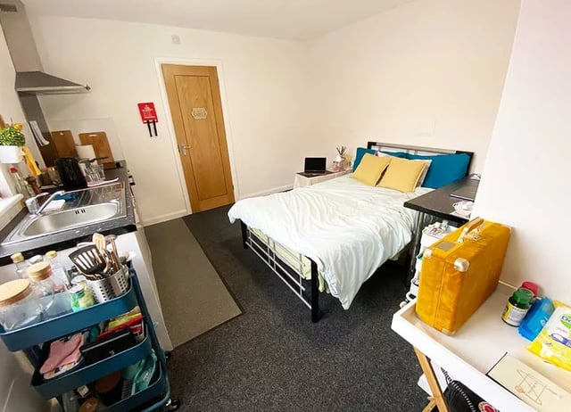 Kitchen sink bed desk and yellow suitcase Bedroom at Forest Rise in Loughborough Student Accommodation