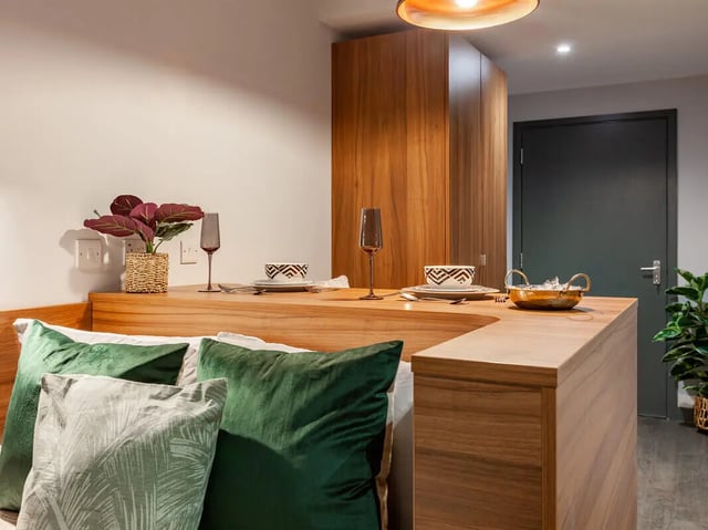 Pillows on bed with table and plant bedroom at Straits Garden in Egham Student Accommodation