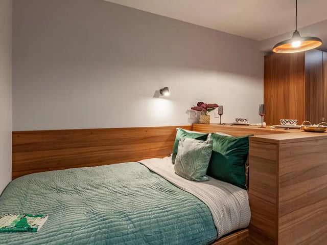 Bed with green quilt and pillows bedroom at Straits Garden in Egham Student Accommodation