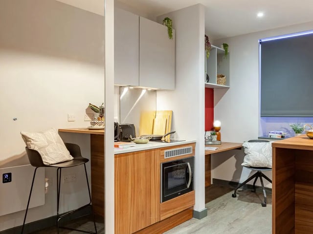 Compact kitchen with bar stool and desk area kitchen at Straits Garden in Egham Student Accommodation