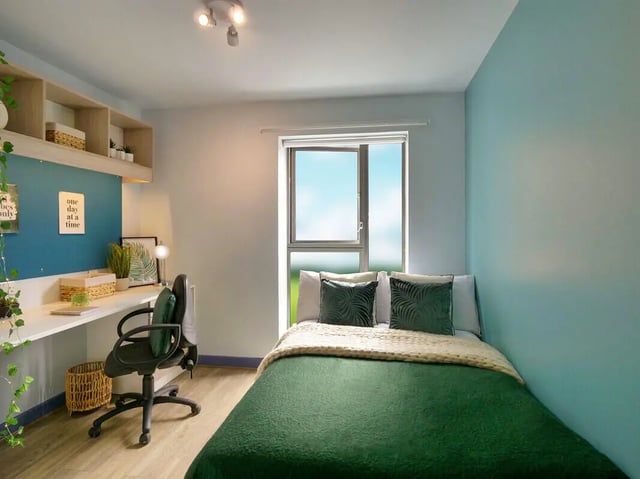 Desk bed shelves basket and chair bedroom at Bright House in Kingston Upon Thames Student Accommodation
