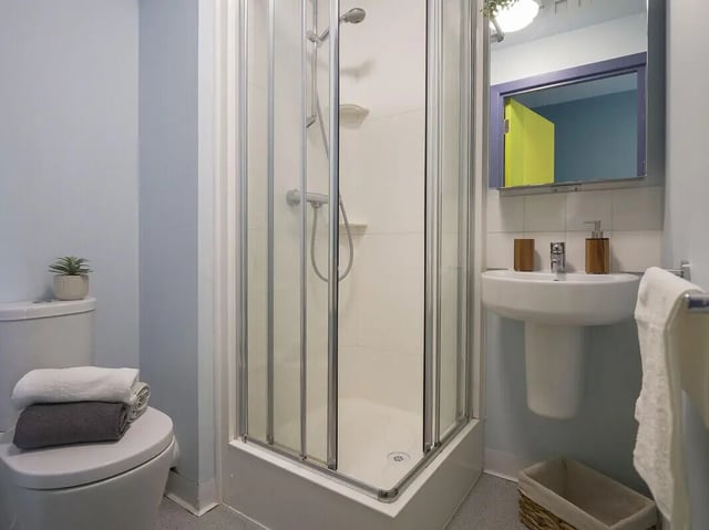 Toilet shower sink with toiletries and towels bathroom at Bright House in Kingston Upon Thames Student Accommodation
