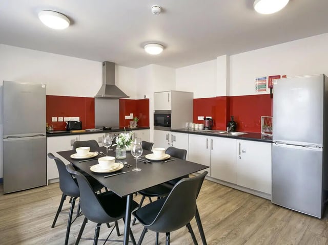 Table chairs fridges and cabinets kitchen at Bright House in Kingston Upon Thames Student Accommodation