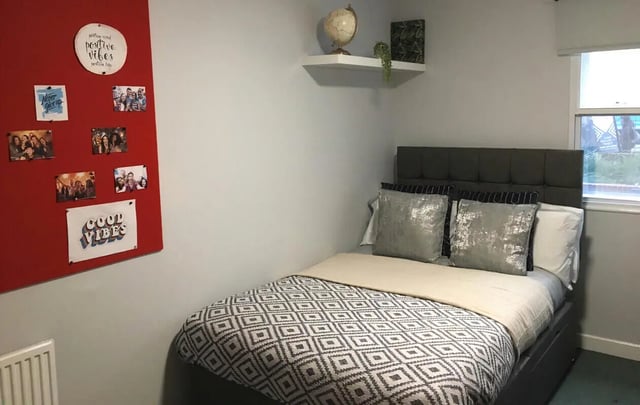 Bed photos on red board globe shelf bedroom at Dean House in London Student Accommodation