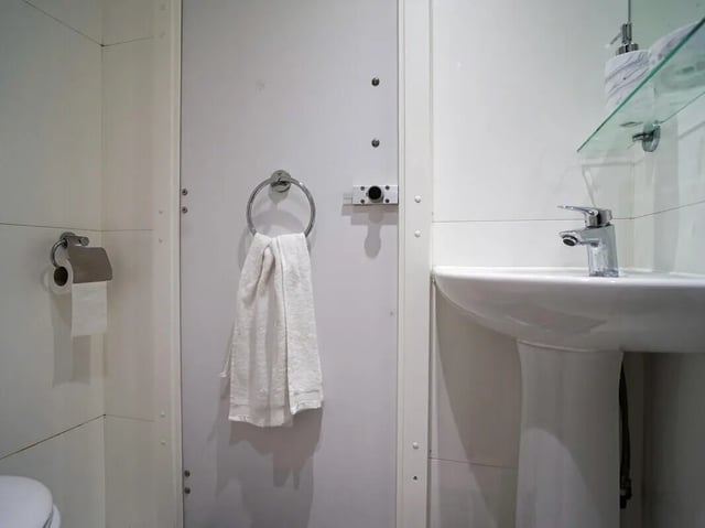 Toilet roll towel and sink bathroom at Dean House in London Student Accommodation
