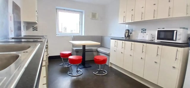Sink microwave red stools table and bench seating kitchen at Hamwic Hall in Southampton Student Accommodation