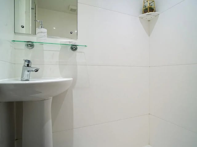 Sink soap dispenser mirror shelf bathroom at Dean House in London Student Accommodation