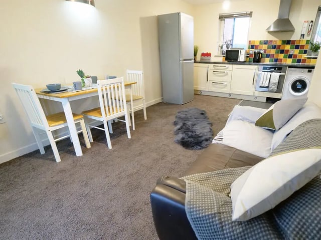 Dining table chairs sofa and kitchen living room at Hassells Bridge House in Newcastle Under Lyme Student Accommodation
