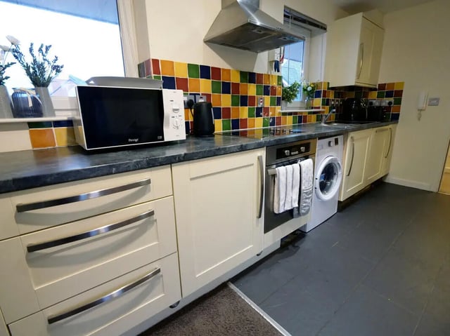 Microwave kettle oven and washing machine kitchen at Hassells Bridge House in Newcastle Under Lyme Student Accommodation