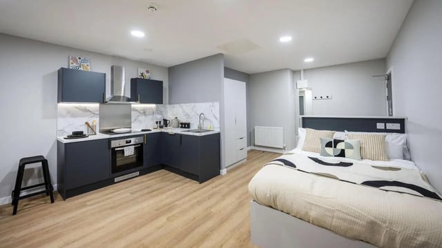 Modern studio kitchen with bed and storage. at Clyde Court in Glasgow Student Accommodation