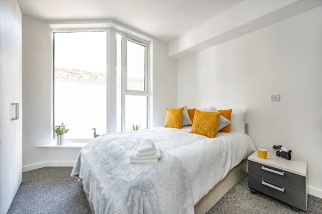 Bed with yellow pillows and white bedding bedroom at Foundry Studios in Lancaster Student Accommodation