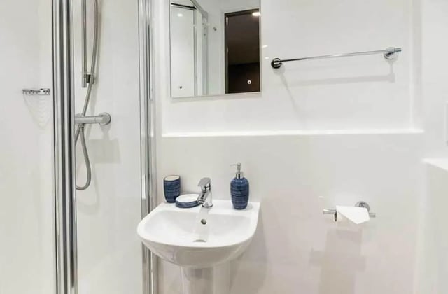 Shower sink soap dispenser and toilet paper holder bathroom at Ernest Place in Durham Student Accommodation