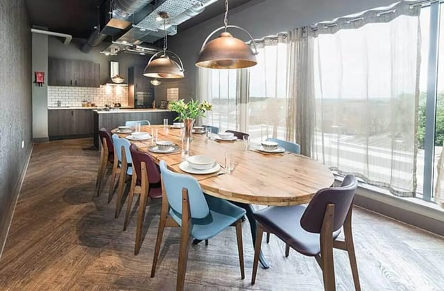 Large wooden table chairs and kitchen area dining room at Ernest Place in Durham Student Accommodation