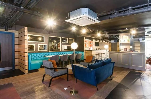 Modern lounge area with turquoise banquette and bar Living room at Ernest Place in Durham Student Accommodation
