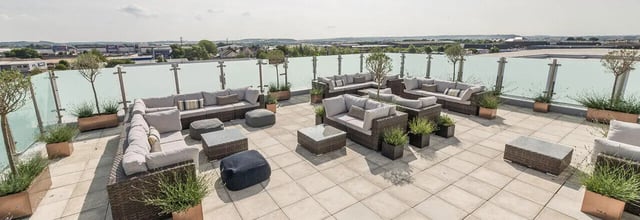 Rooftop lounge area with multiple seating groups patio. at Ernest Place in Durham Student Accommodation
