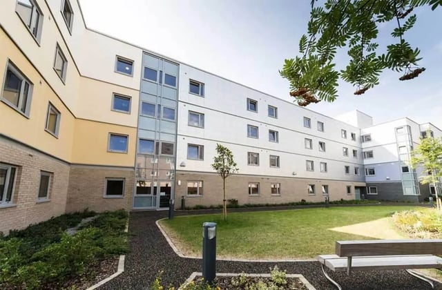 Modern student accommodation building with grass and bench Exterior at Ernest Place in Durham Student Accommodation