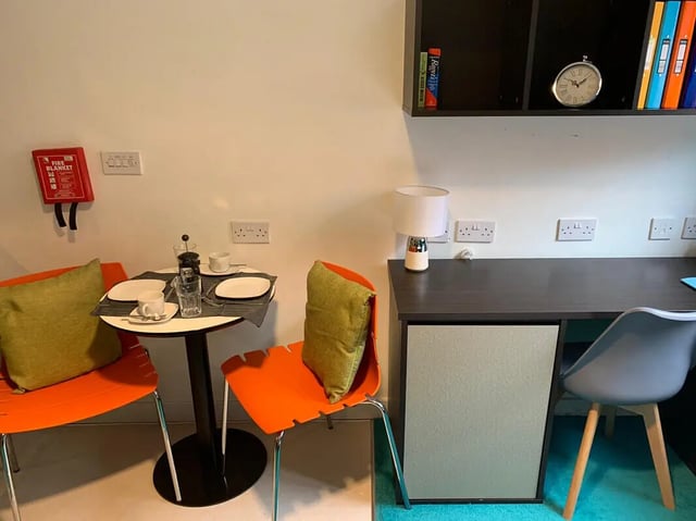 Table chairs fire blanket and desk study area at Plato House in Liverpool Student Accommodation