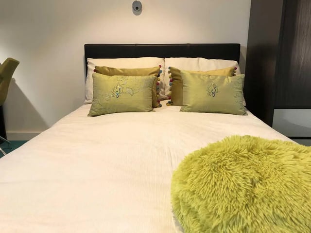 Bed with decorative pillows fluffy throw bedside cabinet Bedroom at Plato House in Liverpool Student Accommodation