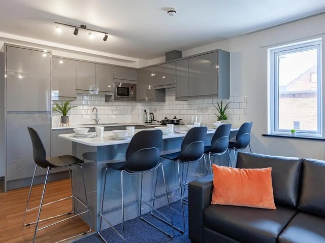 Modern kitchen with island seating living room at Trinity Student Village in Preston Student Accommodation