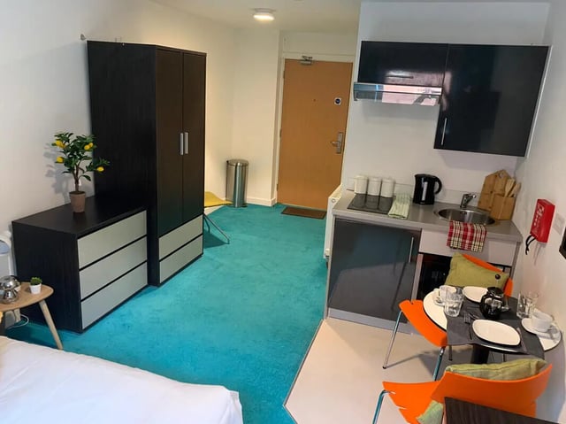 Wardrobe dresser sink kettle chairs table kitchen living room at Plato House in Liverpool Student Accommodation
