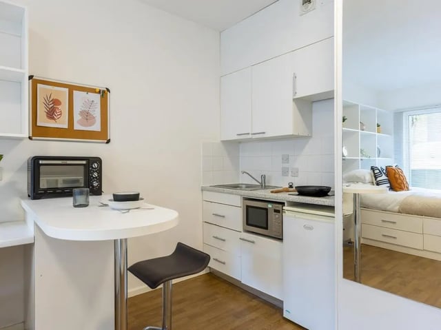 Kitchenette with bar stool mini oven and fridge bedroom studio at St Augustine's House in Plymouth Student Accommodation