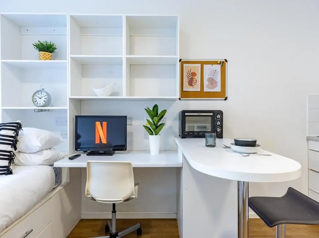 Bed study area with TV microwave and desk living room at St Augustine's House in Plymouth Student Accommodation