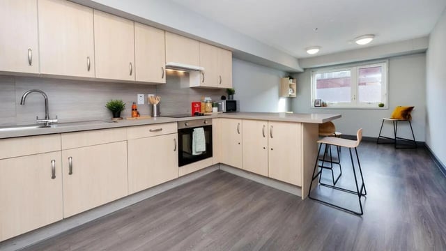 Modern kitchen with light wood cabinets and breakfast bar kitchen at The Forge in Sheffield Student Accommodation