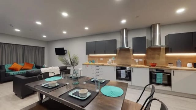 Dining table, sofas, kitchen counters, ovens combined living room kitchen at Electric Press in Sheffield Student Accommodation