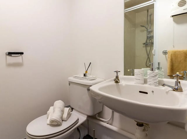 Toilet sink and shower reflected in mirror bathroom at The Print House in Loughborough Student Accommodation