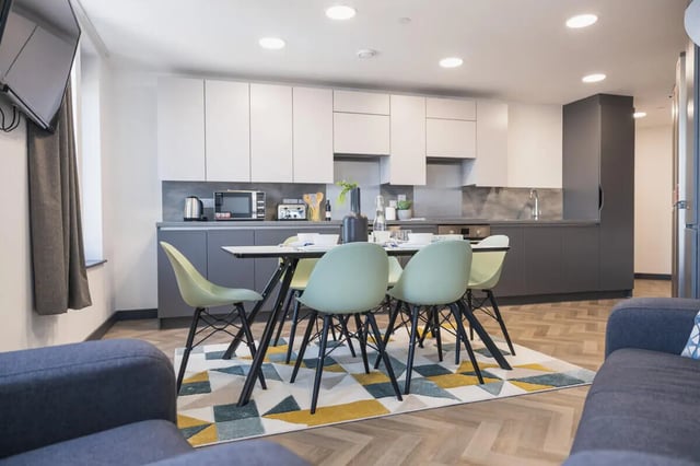 Modern kitchen dining area with light mint chairs at Onyx Birmingham in Birmingham Student Accommodation