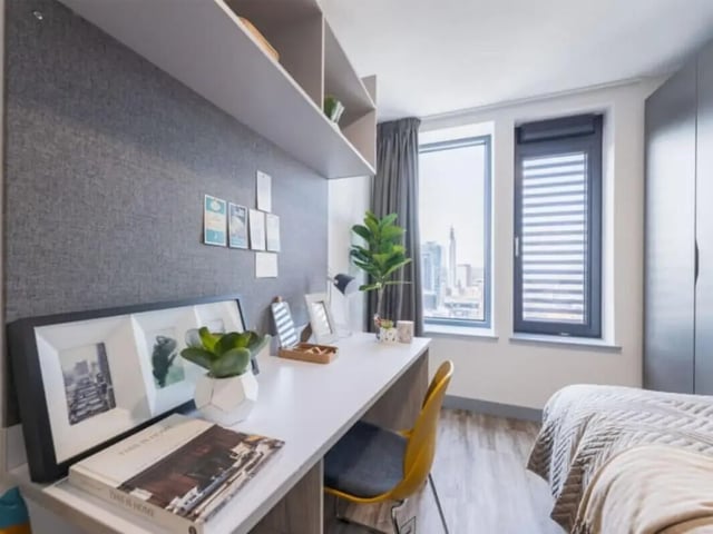 Desk framed photos plant chair bed bedroom at Onyx Birmingham in Birmingham Student Accommodation