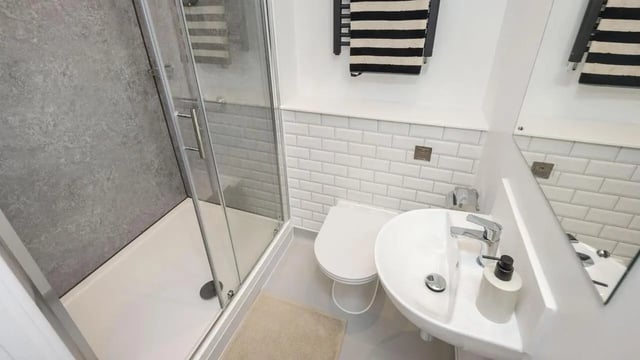 Shower toilet sink soap dispenser towels bathroom at Headrow Court in Leeds Student Accommodation