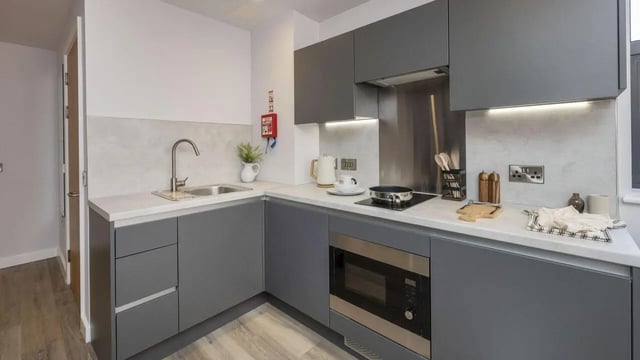 Modern grey kitchen with sink microwave kettle and hob kitchen at Headrow Court in Leeds Student Accommodation