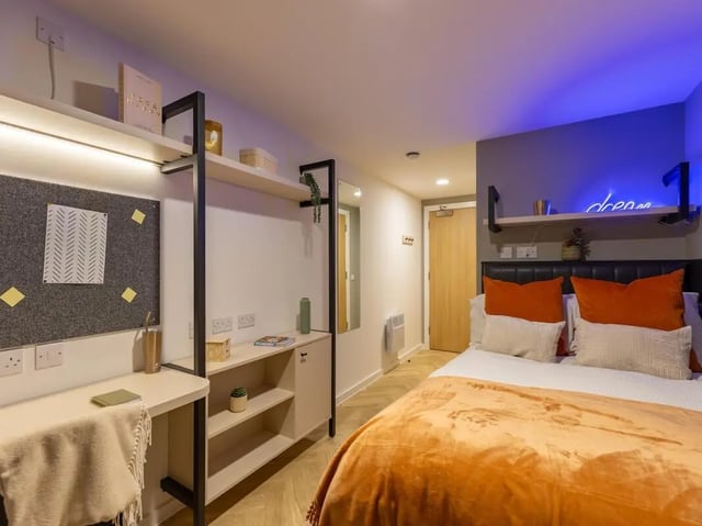 Desk bed with orange pillows and blanket bedroom at Arcadian in Nottingham Student Accommodation