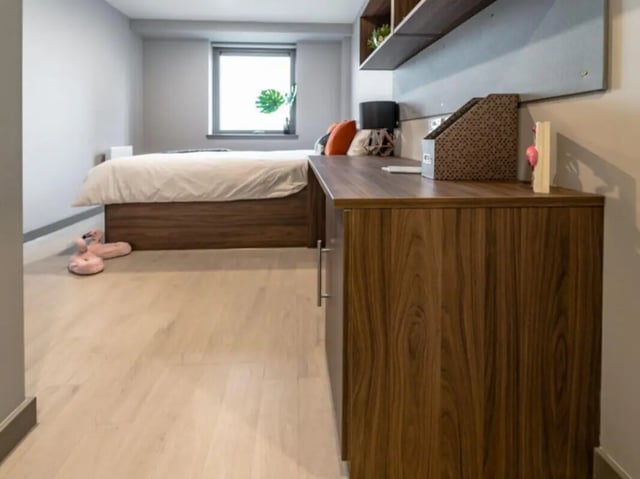 Bed desk and slippers student bedroom at Scotway House in Glasgow Student Accommodation