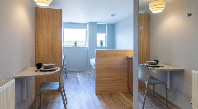 Dining tables chairs and a bed Study bedroom at Renslade House in Exeter Student Accommodation