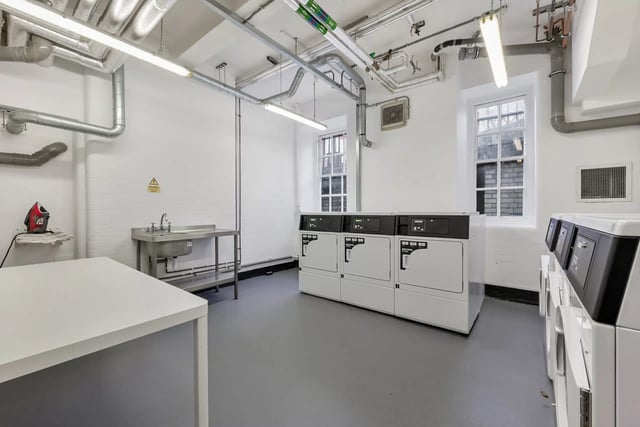 Washing machines sinks and folding table laundry room at AXO Waterloo in London Student Accommodation