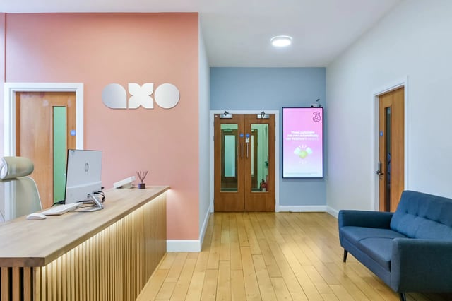 Reception desk computer dual doors screen blue sofa lobby at AXO Waterloo in London Student Accommodation