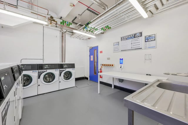Washing machines table and sink laundry room at AXO Waterloo in London Student Accommodation
