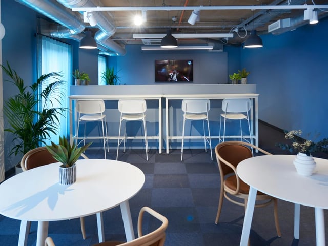 White tables chairs and bar with screen living room at The Gorge in Exeter Student Accommodation