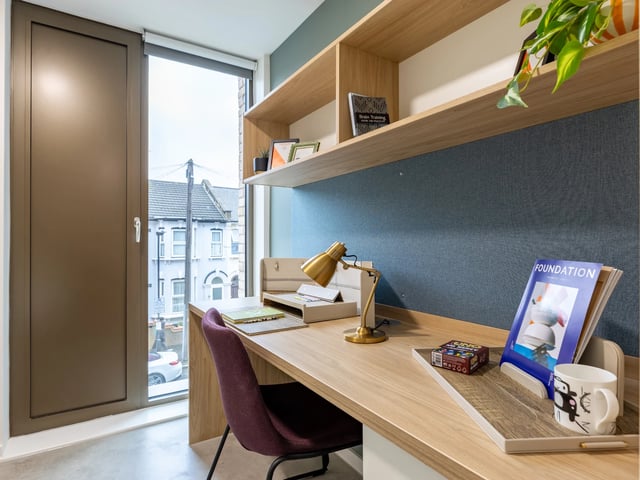 Desk chair lamp and shelves with books study area at Venti House in London Student Accommodation
