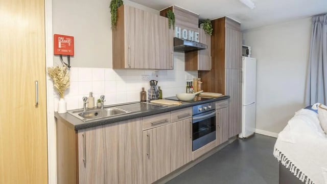 Kitchen with sink oven fire blanket and couch kitchen at The Pinnacles in Sheffield Student Accommodation